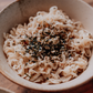 Noodles with seasoning in a bowl on a wooden surface